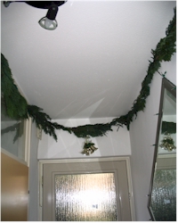 Kerstdecoratie - guirlande in de hal Guirlande met lampjes opgehangen in de hal